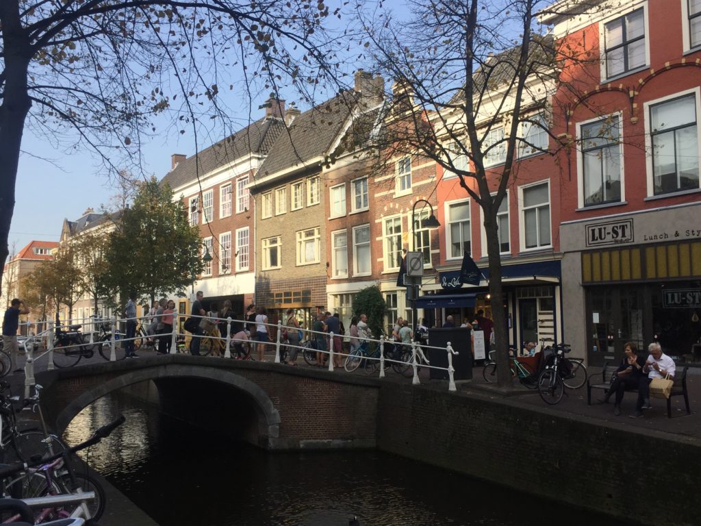 A bridge over Delft canals with the sun shining on some of the houses